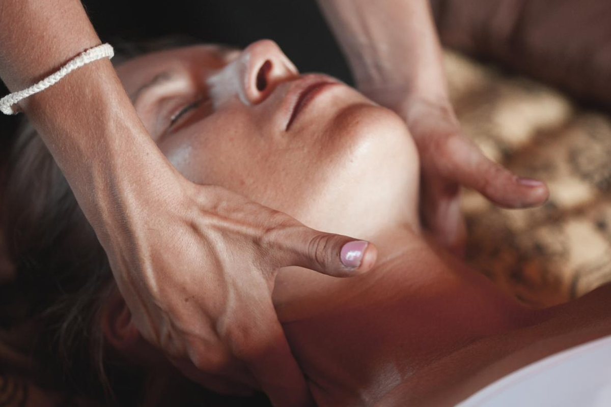 Esthetician performing a facial massage during a holiday skin treatment at Lemon & Honey Day Spa in the City of Orange, CA