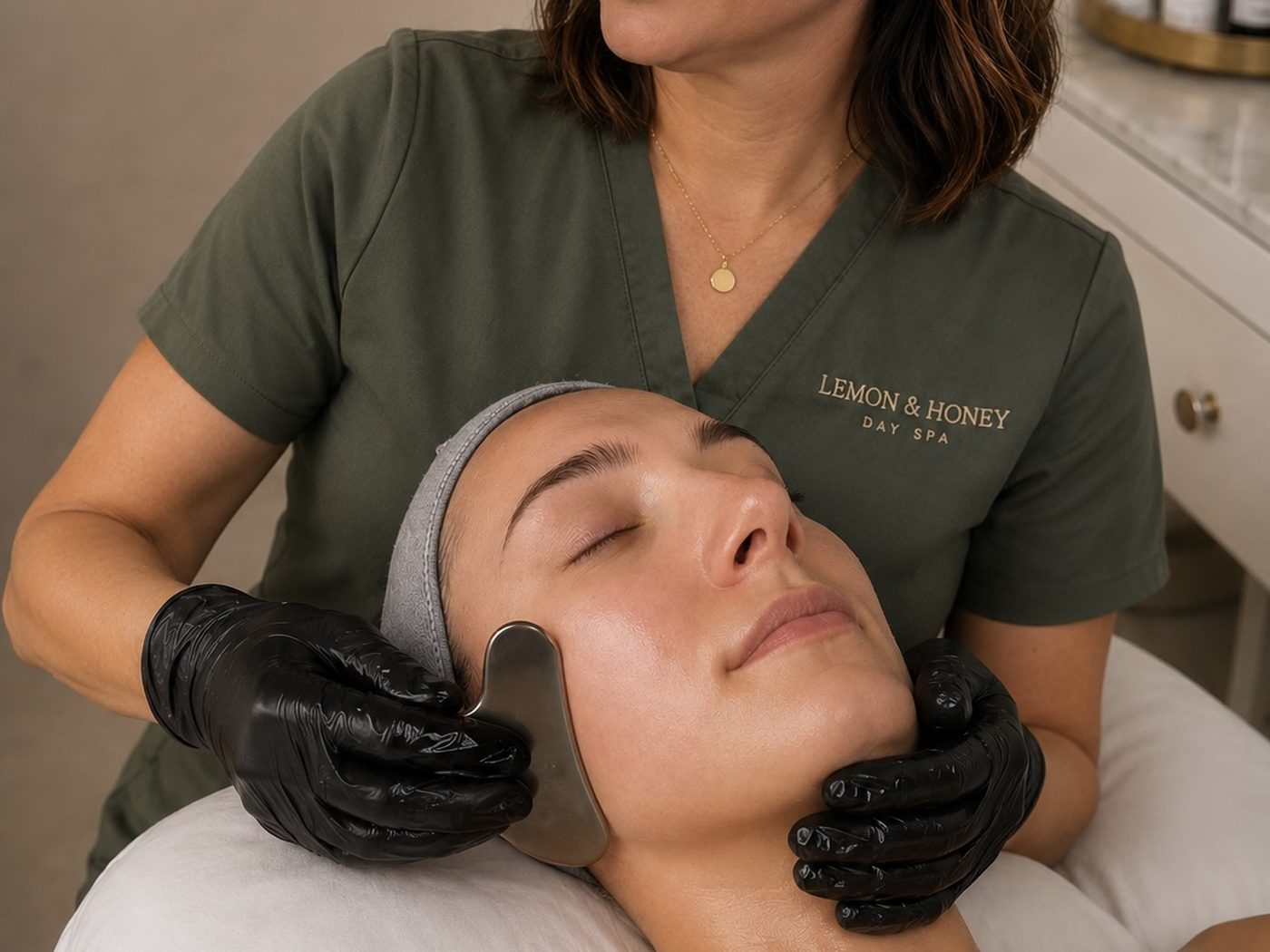 Esthetician performing a Honey Gua Sha Facial at Lemon & Honey Day Spa in the City of Orange, CA
