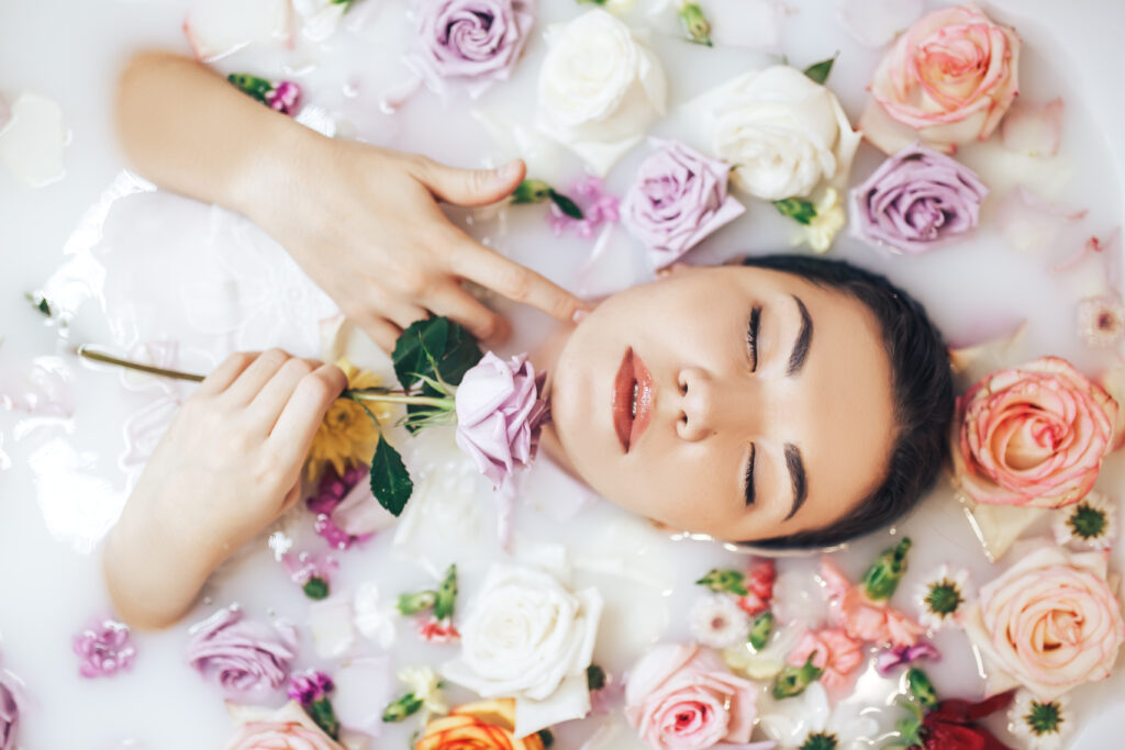 Woman trying out hydrotherapy at home with a facial steam bath filled with flowers.