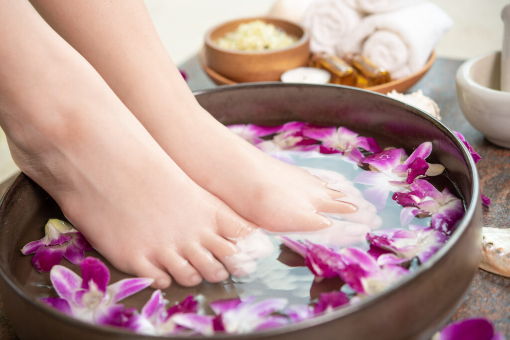 Homemade foot soak with herbs and a bucket.